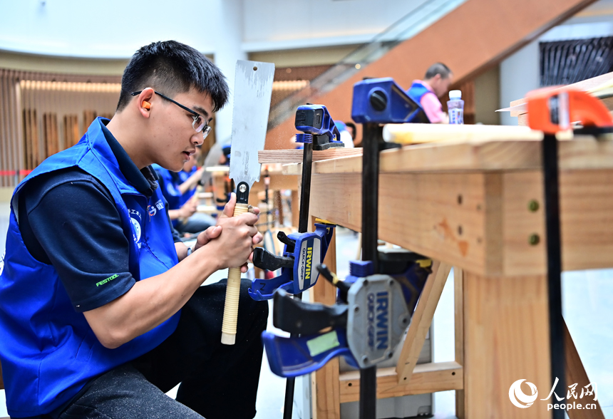 贛州市南康區家居小鎮博覽中心，幾十名木匠工人在手工木工（木制家具工）職業技能競賽決賽中制作家具。人民網 朱海鵬攝