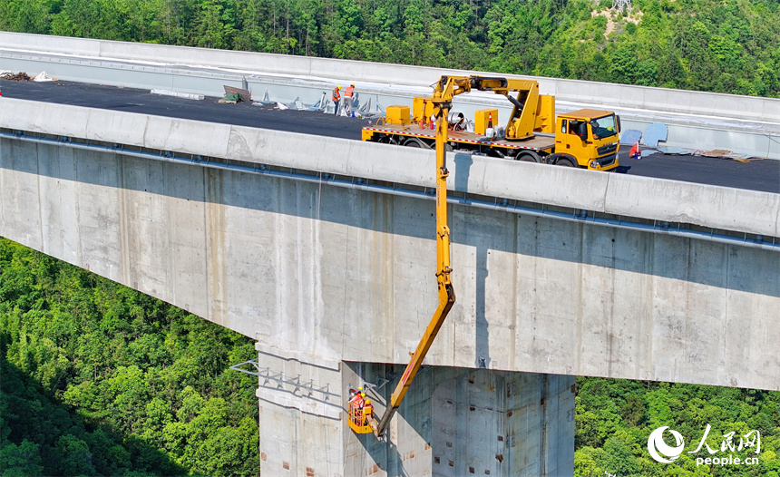 贛州市上猶縣陡水鎮的遂大高速上猶江特大橋項目施工現場，工人在進行大橋收尾施工。人民網 朱海鵬攝