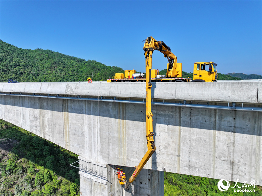 贛州市上猶縣陡水鎮的遂大高速上猶江特大橋項目施工現場，工人在進行大橋收尾施工。人民網 朱海鵬攝