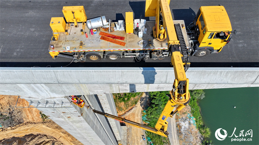 贛州市上猶縣陡水鎮的遂大高速上猶江特大橋項目施工現場，工人在進行大橋收尾施工。人民網 朱海鵬攝