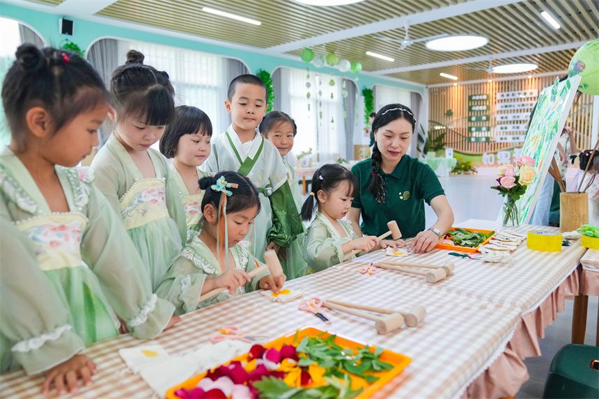 江西省撫州市臨川區保育院里，老師指導孩子們敲印染。郭昊攝