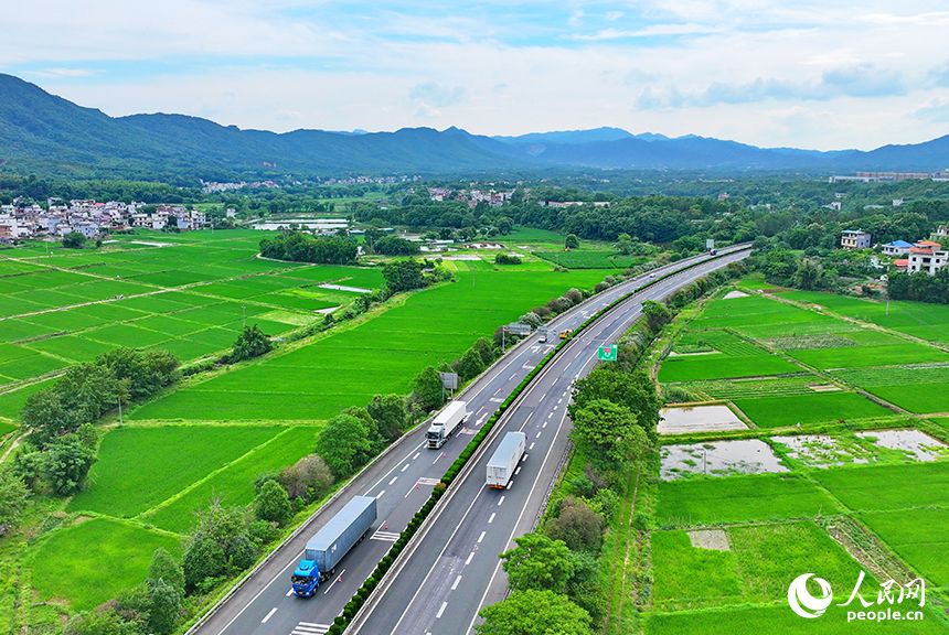贛州市南康區龍回鎮龍東村，車輛在大廣高速公路上往來馳騁，沿線鄉村田園夏日美景怡人。人民網 朱海鵬攝