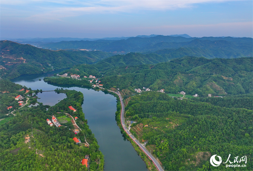 贛州市上猶縣陡水鎮，車輛在農村公路上行駛，沿線水清景美綠意濃。人民網 朱海鵬攝