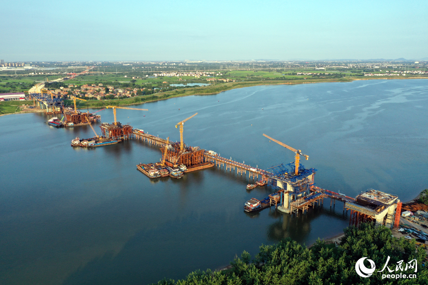 昌南大橋的施工現場塔吊林立，施工人員在汛期搶抓工期，為大橋建設按下“快進鍵”。人民網記者 時雨攝
