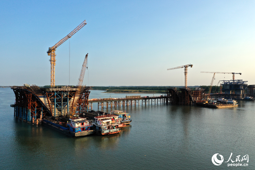 昌南大橋的施工現場塔吊林立，施工人員在汛期搶抓工期，為大橋建設按下“快進鍵”。人民網記者 時雨攝