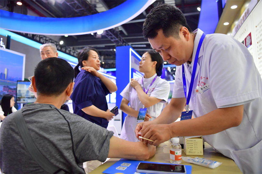 在國際大健康產業大會暨博覽會上，中醫醫生為患者進行針灸。人民網記者 時雨攝