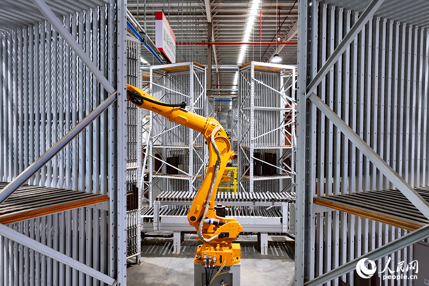 智能制造企業車間內，智能機器人手臂快速運轉，板材分揀包裝有序進行。人民網 朱海鵬攝