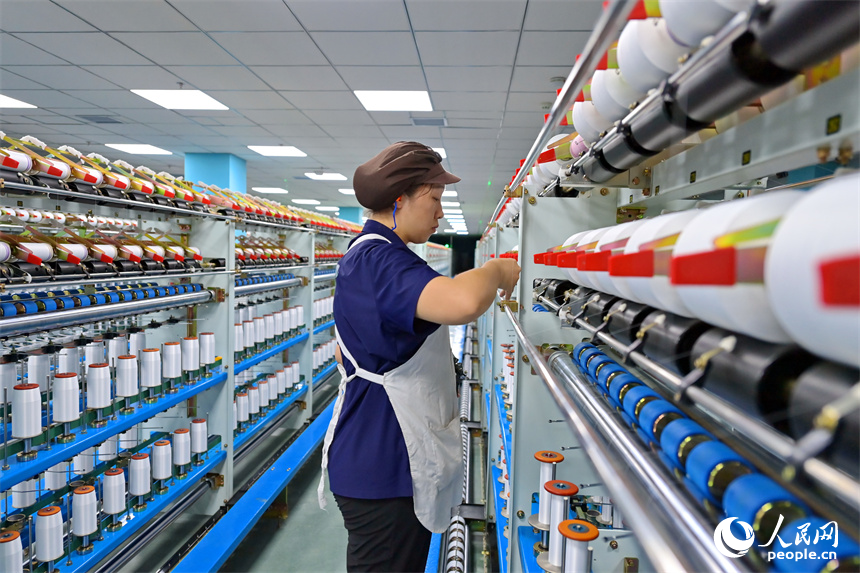 江西申華新材料有限公司5G智慧車間內，工人在加工錦綸紡絲新材料產品。人民網 朱海鵬攝