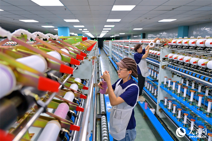 江西申華新材料有限公司5G智慧車間內，工人在加工錦綸紡絲新材料產品。人民網 朱海鵬攝
