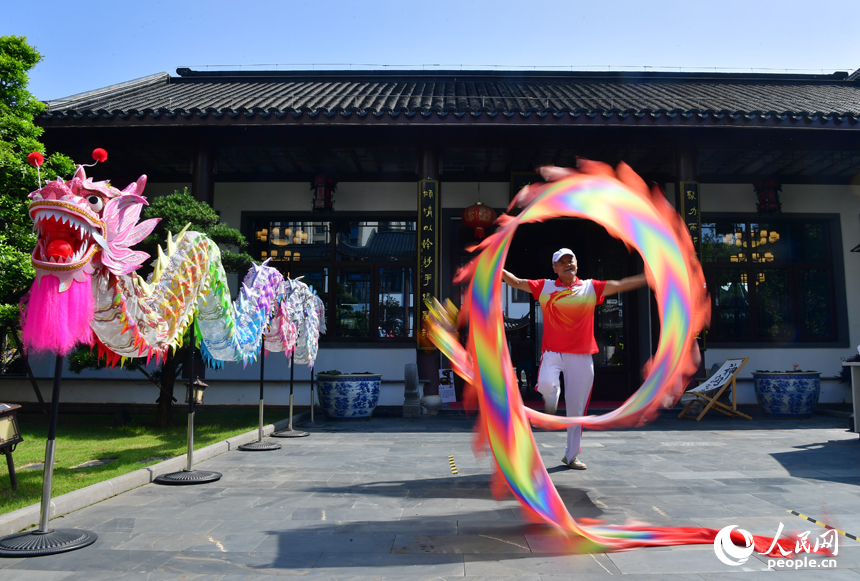 一名非物質文化遺產代表性傳承人正在集市現場舞龍。人民網記者 時雨攝