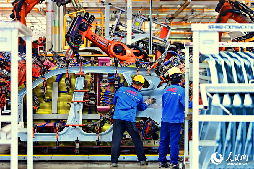 江鈴汽車富山工廠數字化車間內，智能焊裝機械臂有序運轉，工人在生產線上忙碌。人民網 朱海鵬攝