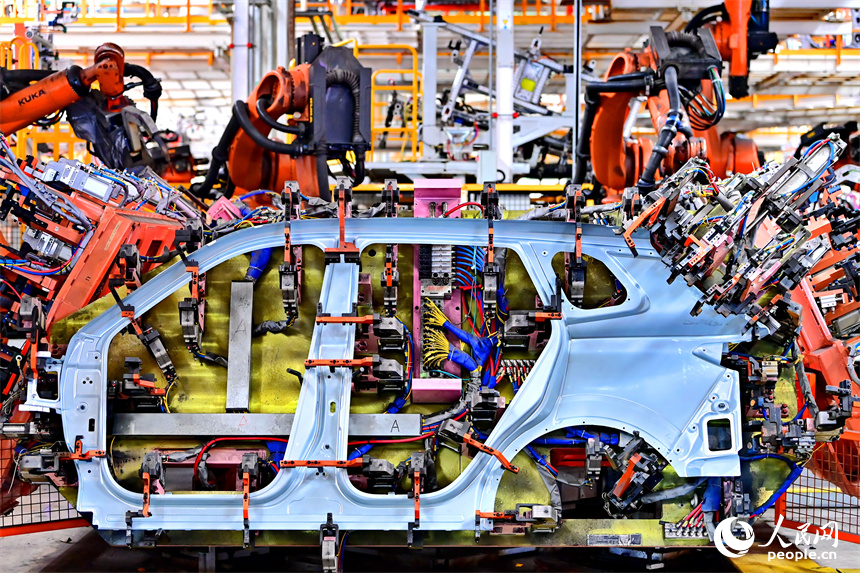 江鈴汽車富山工廠數字化車間內，智能焊裝機械臂有序運轉，工人在生產線上忙碌。人民網 朱海鵬攝
