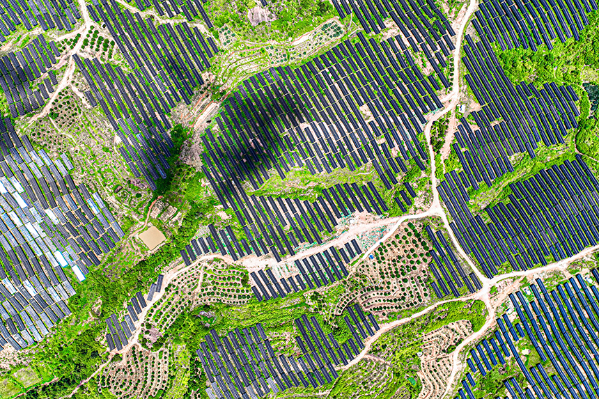 鱗次櫛比的光伏組件分布在荒山坡上，與延綿群山相映相襯，構成一道獨特的風景線。李煜祖攝