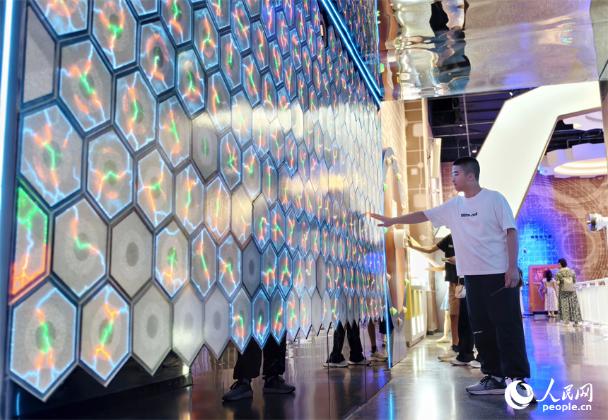 一位學生通過觸摸的方式感受科技魅力。人民網記者 時雨攝