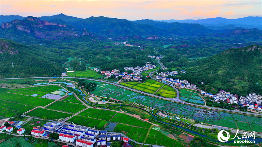 贛州市石城縣琴江鎮前江村，通村道路與村莊、農田、山巒、綠樹相映成趣，構成一幅路暢景美的畫卷。人民網 朱海鵬攝