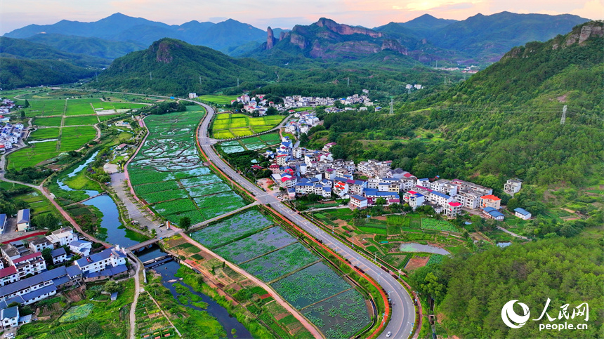 贛州市石城縣琴江鎮前江村，通村道路與村莊、農田、山巒、綠樹相映成趣，構成一幅路暢景美的畫卷。人民網 朱海鵬攝