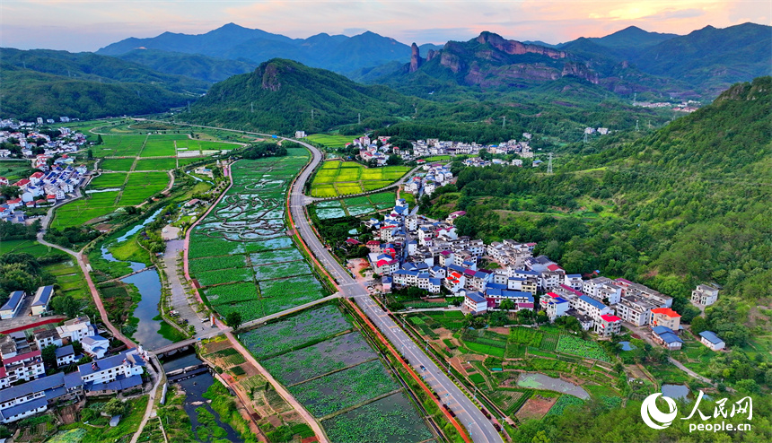 贛州市石城縣琴江鎮前江村，通村道路與村莊、農田、山巒、綠樹相映成趣，構成一幅路暢景美的畫卷。人民網 朱海鵬攝
