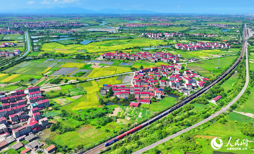 豐城市拖船鎮松湖村，公路、鐵路與周邊鄉村田園、房屋相映成景。人民網 朱海鵬攝