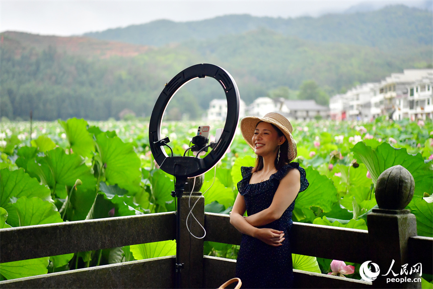 網絡主播在蓮池旁直播推介蓮池美景。人民網記者 時雨攝