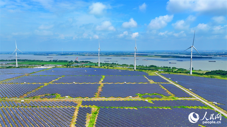 九江市彭澤縣帽子山風光電站，連片的光伏發電板與風力發電機組相得益彰，源源不斷地輸送清潔能源。人民網 朱海鵬攝