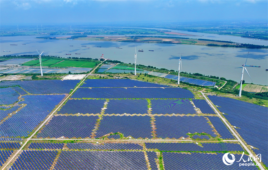 九江市彭澤縣帽子山風光電站，連片的光伏發電板與風力發電機組相得益彰，源源不斷地輸送清潔能源。人民網 朱海鵬攝
