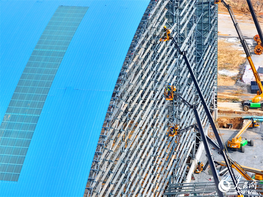 建設者們冒著高溫在高空進行貨棚擋板安裝作業。人民網 朱海鵬攝