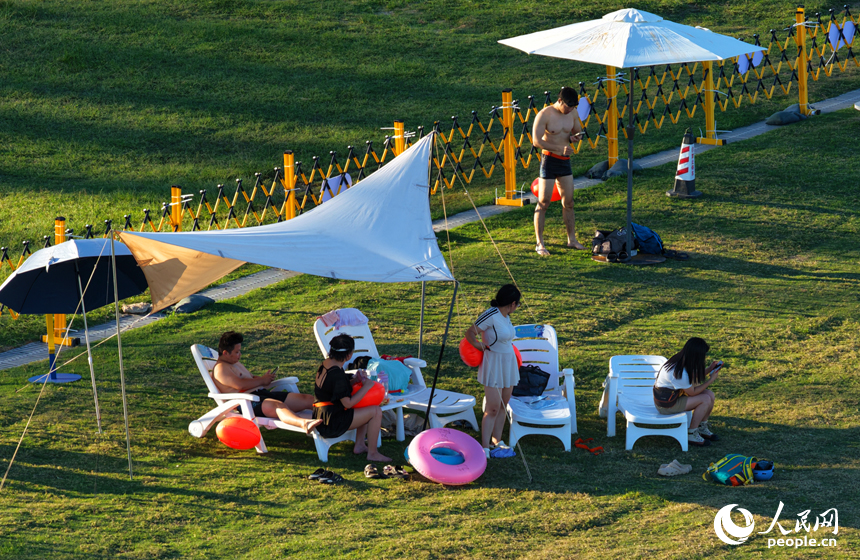 市民游客在南昌市摩天灣天然泳場消暑納涼。人民網記者 毛思遠攝