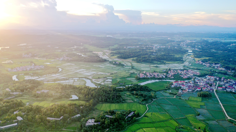 上高縣新界埠鎮五星村，夕陽與田壟、公路、民居、河流構成一幅田園風光畫。陳旗海攝