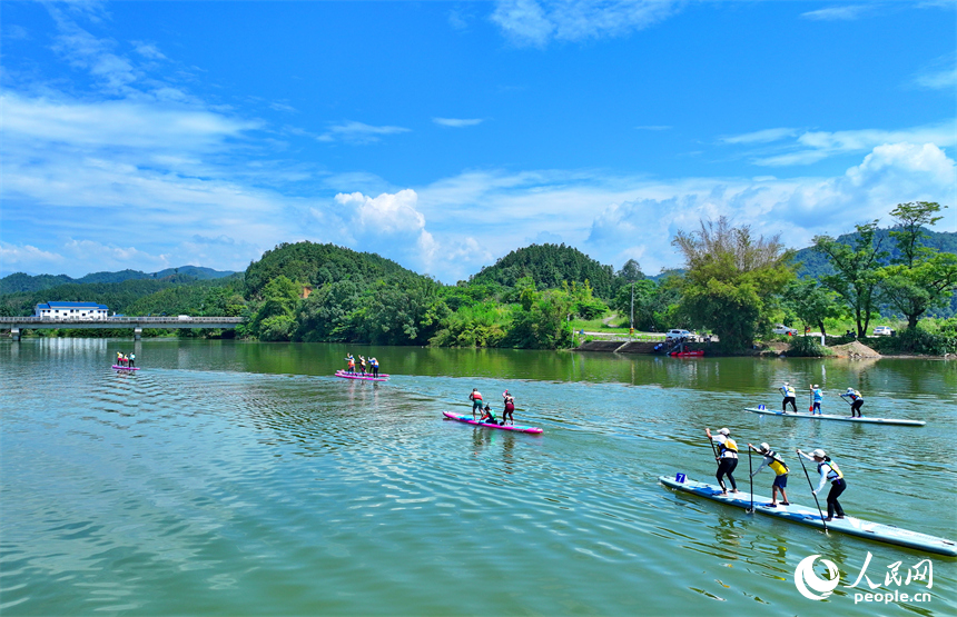 贛州市崇義縣過埠鎮的贛州小漓江，許多槳板運動愛好者在水上劃行競技。人民網 朱海鵬攝
