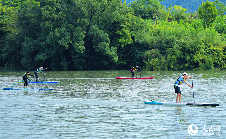 贛州市崇義縣過埠鎮的贛州小漓江，許多槳板運動愛好者在水上劃行競技。人民網 朱海鵬攝