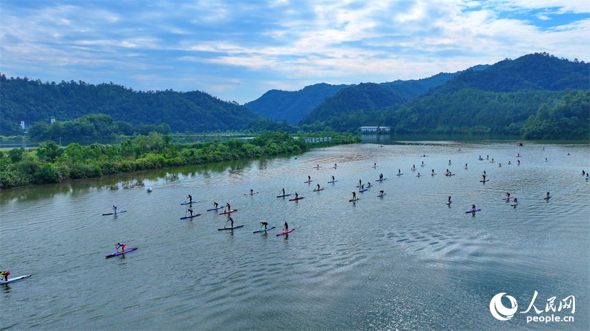 贛州市崇義縣過埠鎮的贛州小漓江，許多槳板運動愛好者在水上劃行競技。人民網 朱海鵬攝