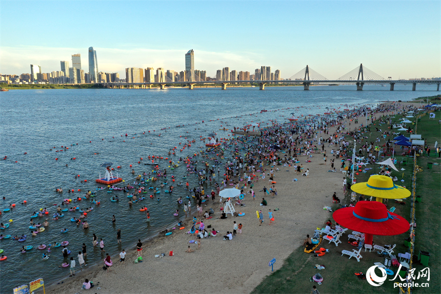 市民和游客在摩天灣的天然泳場戲水納涼。人民網記者 時雨攝