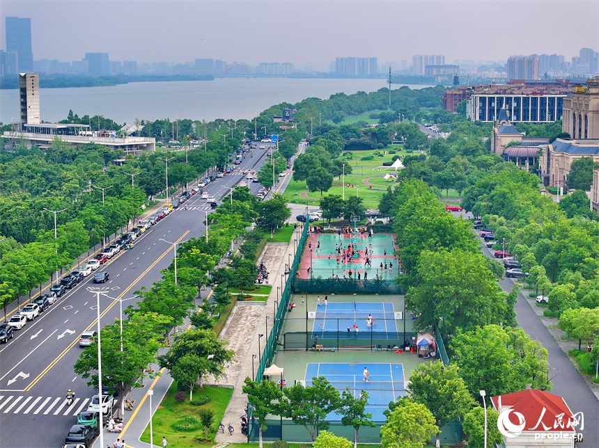 南昌高新區氣膜體育中心室外球場，市民在打網球、打籃球，享受運動健身的樂趣。人民網 朱海鵬攝