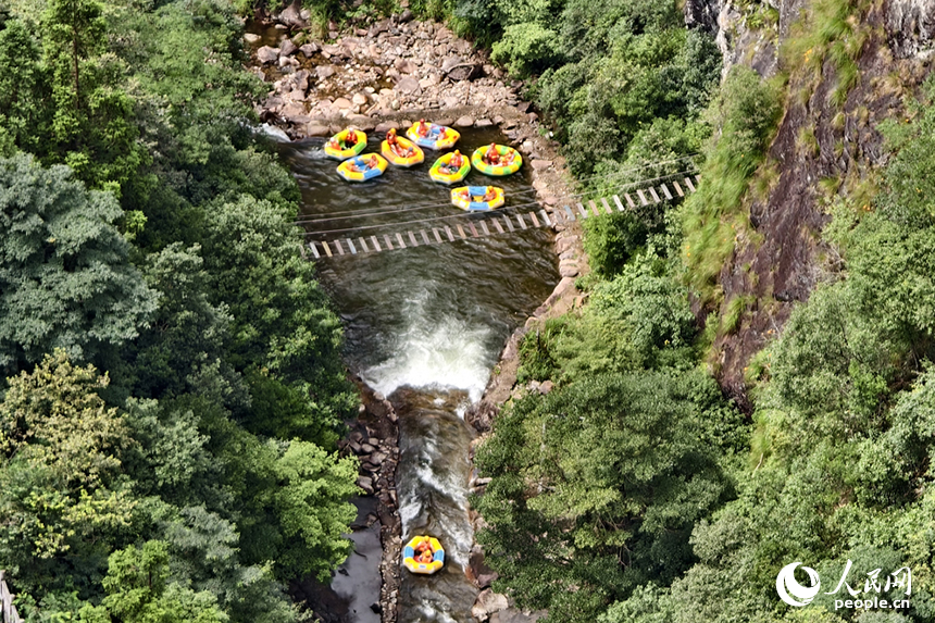 在江西省資溪縣大覺山的漂流水道上，游客們正乘著小艇順流而下，享受山泉水帶來的清涼。人民網記者 時雨攝