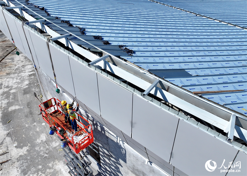 贛州市石城縣西城體育中心項目建設現場，工人冒著高溫在安裝體育場館外立面鋁板。人民網 朱海鵬攝