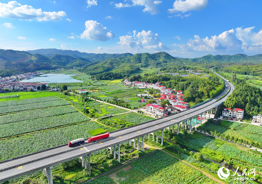 贛州市石城縣小松鎮許坊村，濟廣高速車輛穿行于層巒疊嶂的青山之間，初秋鄉村美景怡人。人民網 朱海鵬攝