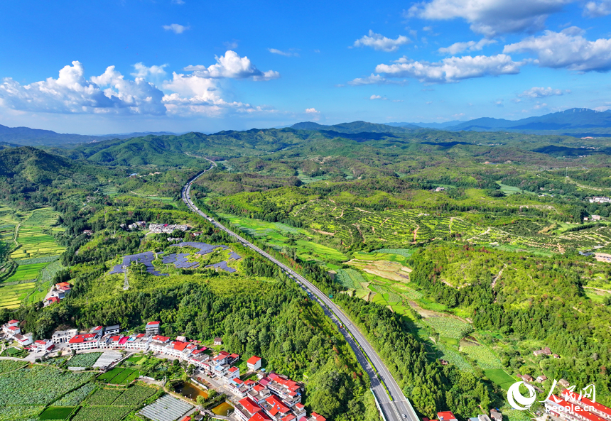 贛州市石城縣小松鎮許坊村，濟廣高速車輛穿行于層巒疊嶂的青山之間，初秋鄉村美景怡人。人民網 朱海鵬攝