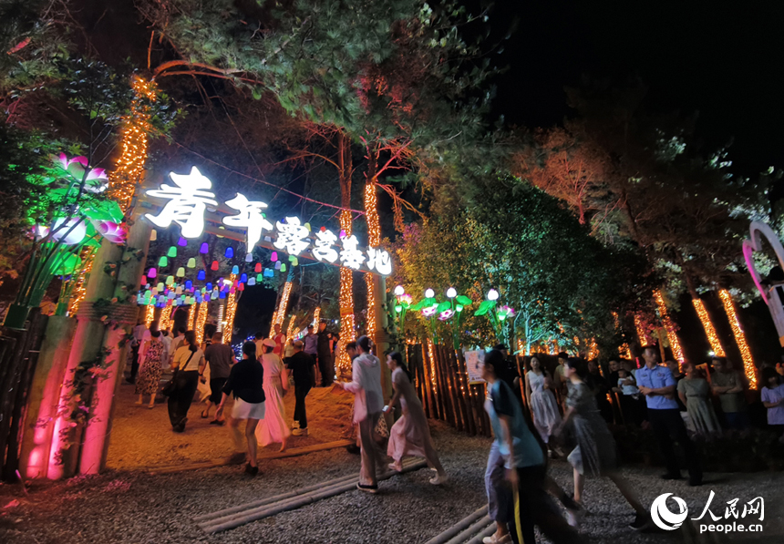 夜晚的荷源公園燈光璀璨，民眾走進公園里的青年露營基地。人民網記者 時雨攝