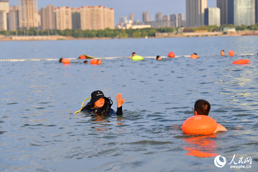 深水區資深安全員正在考核準備進入深水區游泳的市民。人民網記者 時雨攝