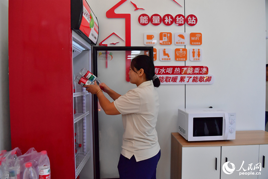 街道志愿者往冰箱補充礦泉水，供網約車司機飲用。人民網記者 時雨攝