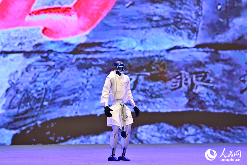 2025江西省網絡文明大會現場，人形機器人化身“詩人”，現場表演誦讀古詩詞，并與同臺表演者合影留念，讓觀眾耳目一新。人民網 朱海鵬攝