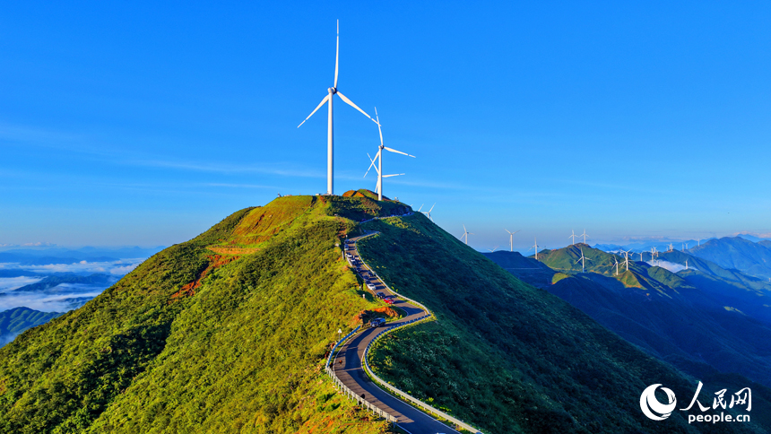 贛州市上猶縣的雙溪草山筑峰頂，新能源風力發電機組與連綿青山相映成景，吸引游客前來觀光打卡。人民網 朱海鵬攝