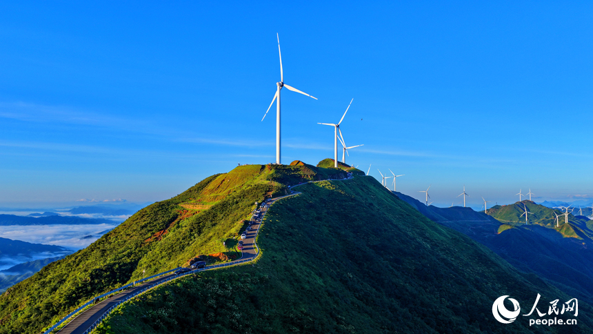 贛州市上猶縣的雙溪草山筑峰頂，新能源風力發電機組與連綿青山相映成景，吸引游客前來觀光打卡。人民網 朱海鵬攝