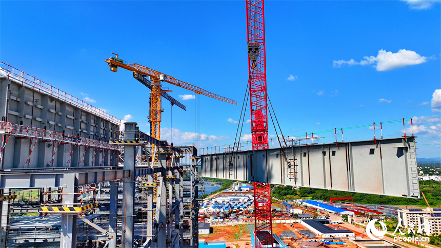 信豐電廠二期項目建設現場塔吊林立，施工作業有序，工人在吊裝鍋爐鋼結構設備。人民網 朱海鵬攝
