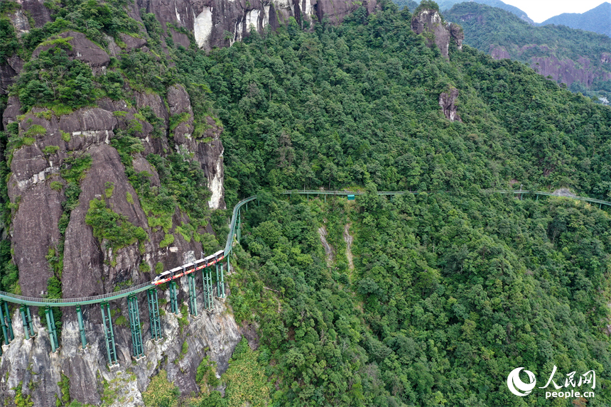 資溪縣大覺山景區，懸崖動車在綠山間穿行，游客們感受“云端飛馳”的刺激與震撼。人民網記者 時雨攝
