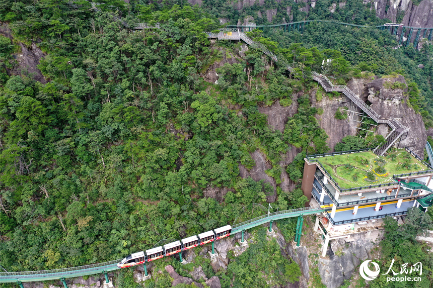 資溪縣大覺山景區，懸崖動車在綠山間穿行，游客們感受“云端飛馳”的刺激與震撼。人民網記者 時雨攝