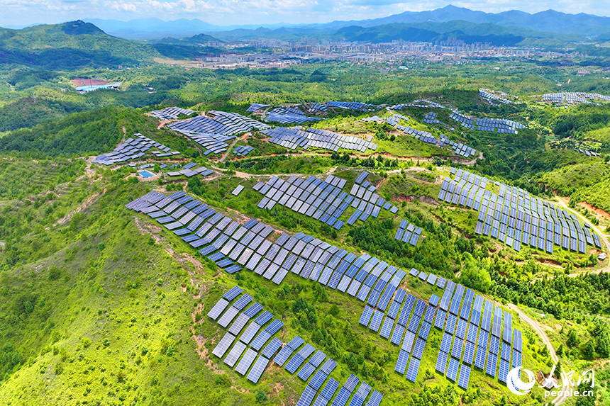 贛州市石城縣琴江鎮的一處光伏發電基地，鱗次櫛比的太陽能光伏板與青山綠樹、村莊田園相映襯，大地如同披上藍色“外衣”。人民網 朱海鵬攝