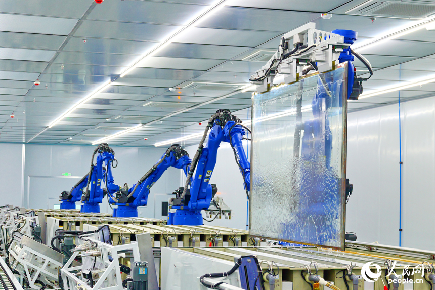 安遠縣產城新區的一家光電科技有限公司智能化生產車間內，一排排機器人揮舞著機械臂加緊作業。人民網 朱海鵬攝