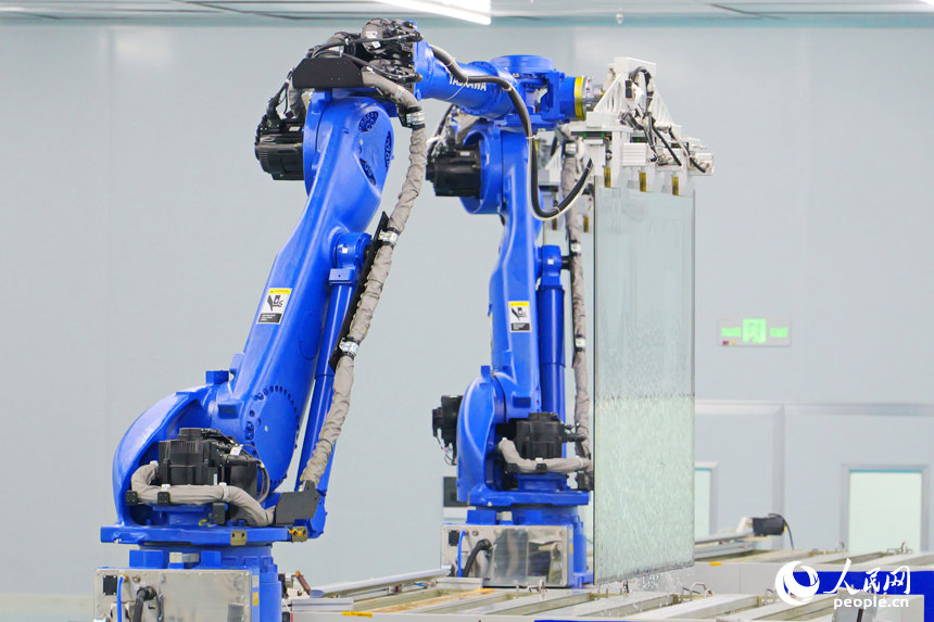 安遠縣產城新區的一家光電科技有限公司智能化生產車間內，一排排機器人揮舞著機械臂加緊作業。人民網 朱海鵬攝