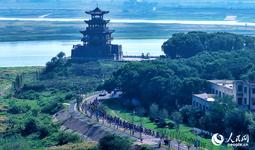 第十三屆環鄱陽湖國際自行車大賽永修站16日在永修縣吳城鎮啟航，圖為選手們在賽道競速。人民網記者 時雨攝